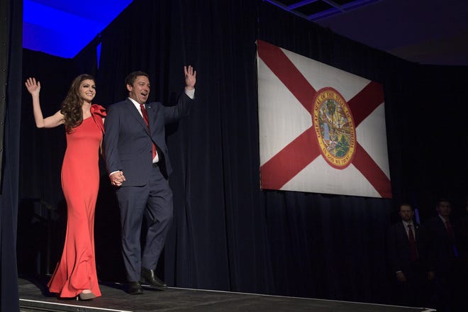 Florida Gov.-elect Ron DeSantis, right, and his wife Casey wave to supporters as they walk onto the stage after he was declared the winner of the election at his party Tuesday, Nov. 6, 2018, in Orlando, Fla. [ PHELAN M. EBENHACK / AP ]