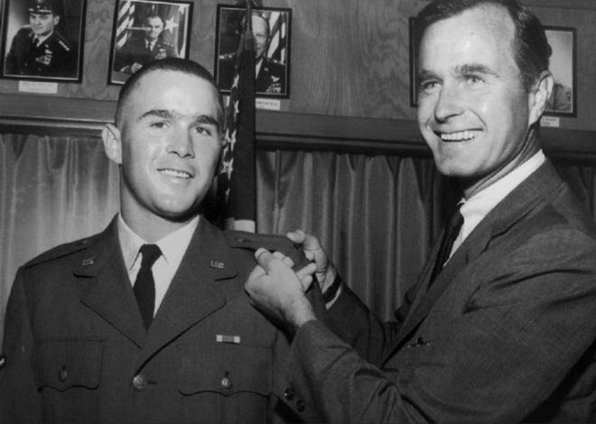 In this 1968 file photo provided by the Texas National Guard, George H.W. Bush, right, is about to pin a lieutenant bar on his son, George W. Bush, after the younger Bush was made an officer in the Texas Air National Guard in Ellington Field, Texas. Bush died at the age of 94 on Friday, about eight months after the death of his wife, Barbara Bush. [ASSOCIATED PRESS]