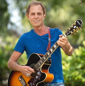 Musician Rick Levy poses with one of his guitars in the backyard of his home in St. Augustine Beach on Thursday. [PETER WILLOTT/THE RECORD]