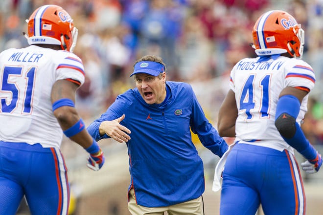 Florida Gators head coach Dan Mullen rushes his team off the field in the 2nd half against Florida State in Tallahassee on Nov. 24. Florida defeated Florida State 41-14. The Gators will face Michigan in the Peach Bowl on Dec. 29. [The Associated Press / Mark Wallheiser]