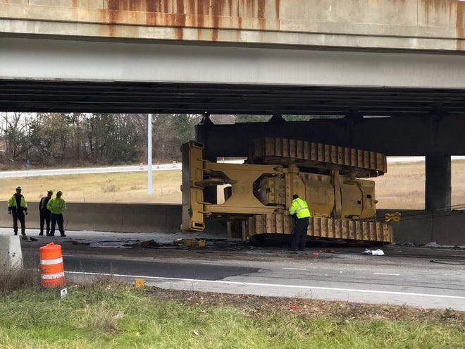 A bulldozer ended up on its side after striking the East Avenue bridge over Interstates 76/77 in Akron when the truck hauling it tried to pass under the bridge early Monday. [Phil Masturzo/Akron Beacon Journal]