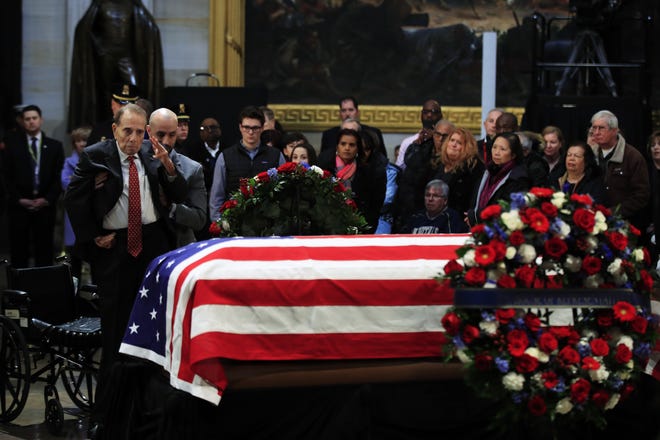 Former Sen. Bob Dole, R-Kan., salutes the flag-draped casket containing the remains of former President George H.W. Bush as he lies in state Tuesday at the U.S. Capitol in Washington. [Manuel Balce Ceneta/The Associated Press]