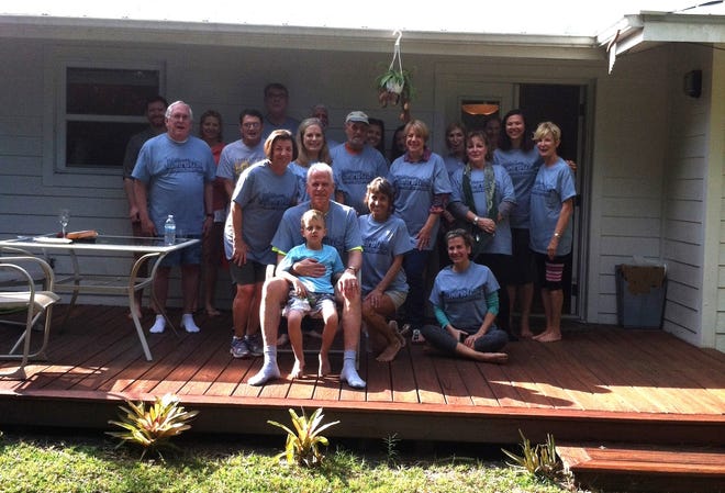 A portion of the walking group, sporting their "Camp Dan" tshirts, on the 70th birthday of group leader Dan Bailey (front center, with grandson Charlie on his lap). "Big Jim" Roque is the tall figure in shadow in the back row. On this occasion he hired a bagpipe player to come to a post-walk brunch and play "Oh Danny Boy." [Photo provided by Carrie Seidman]