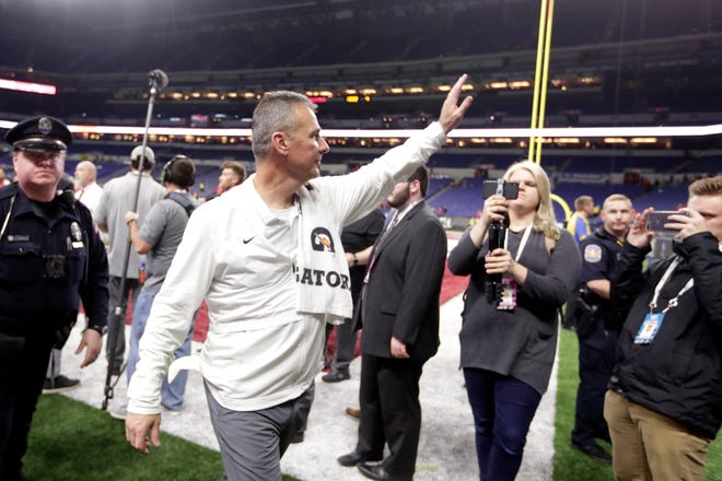 Ohio State head coach Urban Meyer walks off the field early Sunday after Ohio State defeated Northwestern in the Big Ten championship NCAA college football game in Indianapolis.  [ASSOCIATED PRESS]