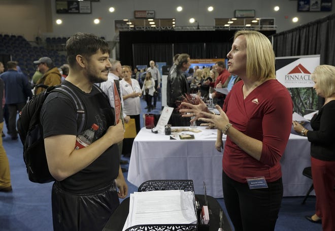 Melanie Lirley of the Pinnacle Specialty Group, right, talks with Logan Hicks about IT related job possibilities at the job fair hosted by SRNS and NNSA for MOX employees to help them find a job at SRS or in that area as the facility closes at the USCA Convocation Center in Aiken, SC. on Wednesday, December 5, 2018. [MIKE ADAMS/SPECIAL]