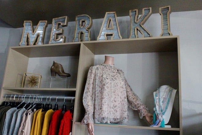 Meraki sign to the right of the entrance with shelf decorations.