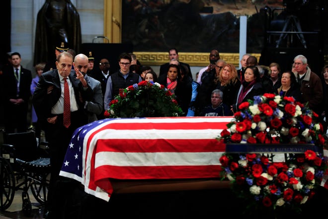 Former Sen. Bob Dole salutes the flag-draped casket containing the remains of former President George H.W. Bush as he lies in state at the U.S. Capitol in Washington, D.C. on Tuesday. Soldiers, citizens in wheelchairs and long lines of others on foot wound through the hushed Capitol Rotunda on Tuesday to view Bush's casket and remember a president whose legacy included World War military service and a landmark law affirming the rights of the disabled. After services in Washington, Bush's remains will be returned to Houston to lie in repose at St. Martin's Episcopal Church before burial Thursday at his family plot on the presidential library grounds at Texas A&M University in College Station. His final resting place will be alongside Barbara Bush, his wife of 73 years who died in April. [MANUEL BALCE CENETA/THE ASSOCIATED PRESS]