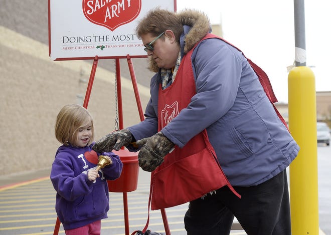 Salvation Army volunteer Cyndee Russell lets Julia Hargerg, 5, of Chippewa Township ring the bell after Julia and her brother put money in the kettle Tuesday outside the Walmart store in Chippewa. [Sally Maxson/BCT staff]