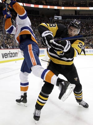 Pittsburgh Penguins' Derek Grant (38) checks New York Islanders' Luca Sbisa during the second period in Pittsburgh, Thursday. [AP Photo/Gene J. Puskar]