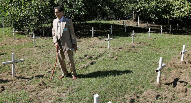 ** FILE ** In this Oct. 21, 2008 file photo, Dick Colon, a member of the White House Boys, walks through grave sites near the Arthur G. Dozier School for Boys in Marianna, Fla. Several men who suffered through severe beatings at what's now called the Arthur G. Dozier School for Boys believe the crosses mark the graves of boys who were killed at the school, victims of punishments that went too far. (AP Photo/Phil Coale, File)