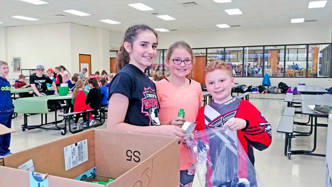 Chippewa Intermediate School fifth-grade students, from left, Aira Regan, Laeney Kenley and Xavier Zollinger fill "blessing bags" for community residents during a Kindness Club meeting.