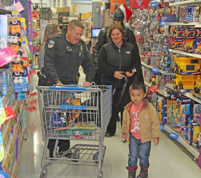 Coldwater Police Officer Jason Goss along with Kristen Crabtree from Central Dispatch and Batman shop with a local youth Thursday at Walmart during the annual Shop with a Cop event.
