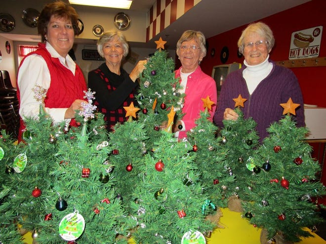 Betsy Brudos, left, Arlene Gesme, Sherry Dickens and Janet Anderson, 
representing the Outreach Ministry at First Lutheran Church, in Geneseo, are shown by some of the miniature Christmas trees which were delivered to residents of two area nursing homes and to shut-in members of the congregation.