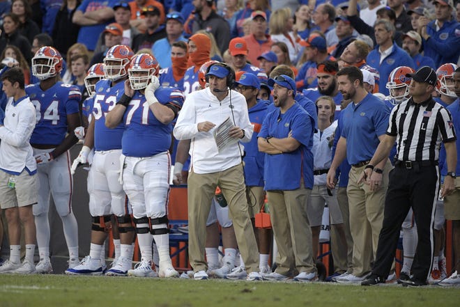 Florida head coach Dan Mullen, center, watches from the sideline during the second half of a Nov. 3 game against Missouri. [AP Photo/Phelan M. Ebenhack]
