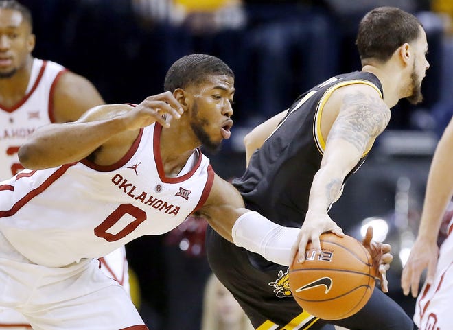 Oklahoma's Christian James, left, gets the ball from Wichita State's Ricky Torres during their matchup Saturday at the Chesapeake Energy Arena in Oklahoma City. [Sarah Phipps/The Oklahoman via AP]