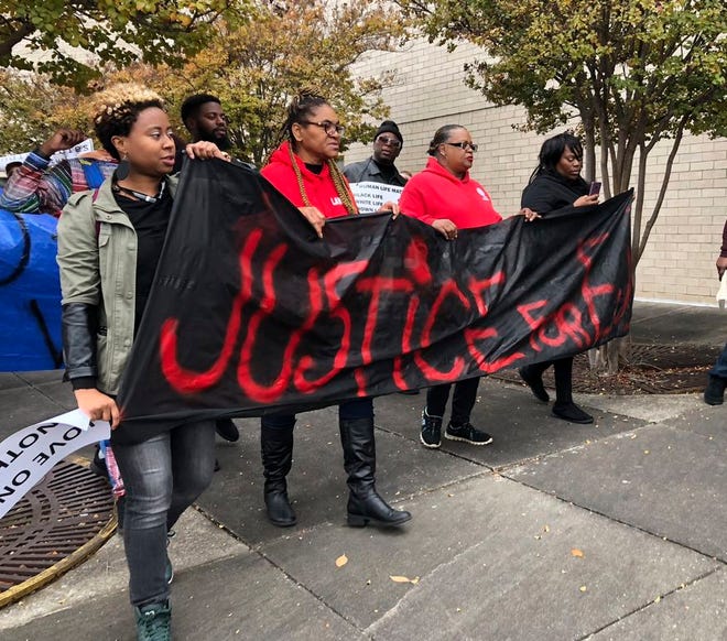 Protestors carry a sign reading "Justice for E.J." during a protest at the Riverchase Galleria in Hoover, Ala., Saturday, Nov. 24, 2018. A police shot and killed 21-year-old Emantic Fitzgerald Bradford, Jr. of Hueytown while responding to a shooting at the mall on Thanksgiving evening. Police said Bradford was fleeing the scene with a weapon. Hoover police initially told reporters Bradford had shot a teen at the mall, but later retracted the statement. (AP Photo/Kim Chandler)