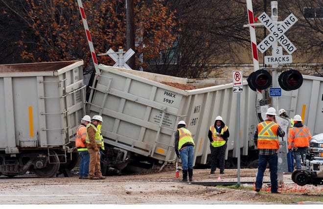 Officials investigate a train derailment in the 2300 block of East Sixth Street, where nine freight cars came off the track Sunday. [Rodolfo Gonzalez/For the American-Statesman]