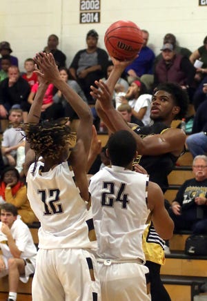 Kings Mountain’s Zeke Littlejohn goes up for a basket against Shelby’s Zarius Hillman and Deleon Hopper during their game at Shelby High School on Tuesday. [Brittany Randolph/The Star]