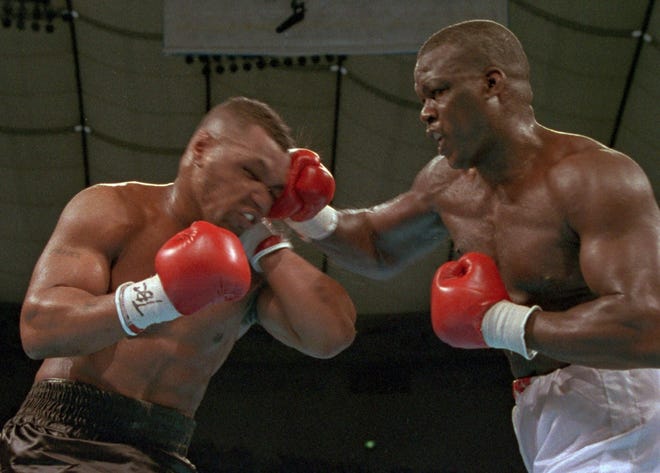 James "Buster" Douglas hits Mike Tyson with a hard right during their world heavyweight title bout in Tokyo on Feb. 11, 1990. Douglas, a Columbus native, was such a heavy underdog that the suggestion that he might win drew laughter during a pre-fight news conference. [Associated Press file photo]