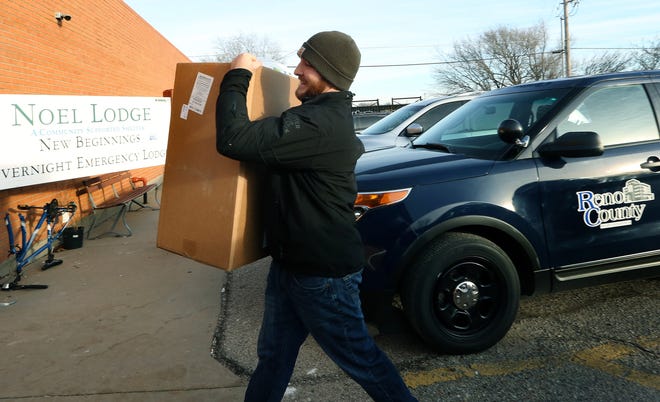 Elliot Koester, an epidemeologist with the Reno County Health Department, carries in a box of supplies donated to the NOEL Lodge Tuesday morning, Dec. 11, 2018. [Sandra J. Milburn/HutchNews]