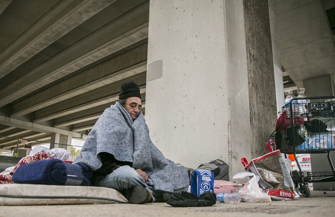 Jerry Ogg, also known on the street as "Chief," sits under Texas 71 and Manchaca Road and says he will try to stay warm with blankets. [RICARDO B. BRAZZIELL/AMERICAN-STATESMAN]