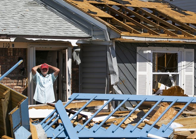 After using a chain saw to cut his way into his vacation home, Lee Perkins takes a break among the devastation in Mexico Beach in this Oct. 15 photo. [Doug Engle/Ocala Star Banner/File]