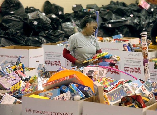 Toys For Tots volunteers sort through donations at the First Apostolic Faith Church.
