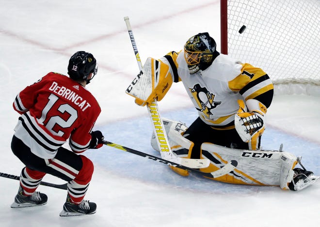 Chicago Blackhawks left wing Alex DeBrincat, left, scores against Pittsburgh Penguins goalie Casey DeSmith during the second period of an NHL hockey game Wednesday, Dec. 12, 2018, in Chicago. (AP Photo/Nam Y. Huh)