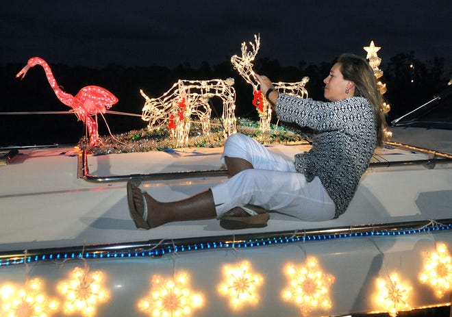 Darlene Johnston of Ocean Ridhe takes a photo as the annual Boynton Delray Beach's Holiday Boat Parade makes its way down the Intracoastal Waterway just north of Ocean Ave. in Boynton Beach on Friday, Dec. 11th, 2009. More than 50 boats participated in the parade, which started at the Boynton Inlet and ended at the C-15 canal in Delray Beach. [SCOTT FISHER/palmbeachpost.com]