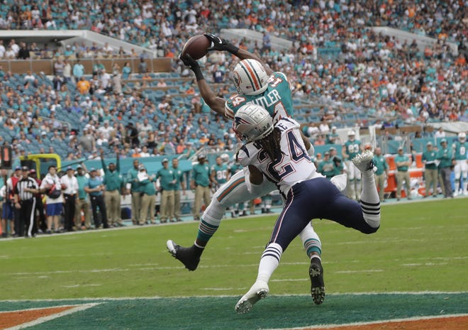 Miami Dolphins wide receiver Brice Butler catches a pass for a touchdown over New England Patriots cornerback Stephon Gilmore on Sunday [LYNN SLADSKY/AP]