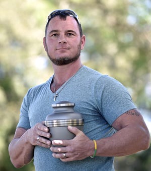 Jason Freeman of Bradenton, grandson of infamous cult leader Charles Manson, holds the urn that once contained Manson’s ashes. [Herald-Tribune staff photo / Thomas Bender]