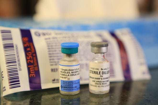 A vial of measles-mump-rubella virus vaccine is seen alongside a vial of sterile solution in 2015. The vaccine is combined with the sterile solution before being administered to a patient. [GateHouse Media]