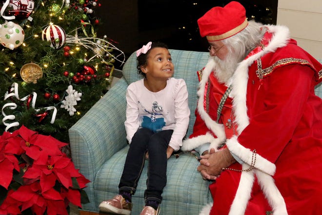Maggie Young shares her Christmas wish list with Santa on Monday, Dec. 10, 2018, during the Mercy Fort Smith Christmas tree lighting and Nativity blessing at Mercy Hospital. The annual event featured Mercy Chaplin Father Norman McFall, Christmas carols, treats and a special visit with Santa. Maggie is the 6-year-old daughter of Kaycee Young of Fort Smith. [JAMIE MITCHELL/TIMES RECORD]