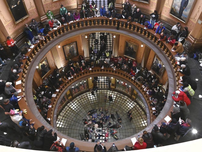 A group of school children visiting the Capitol lie on the floor of the Rotunda while demonstrators make noise and chant as Tthe Michigan Senate and House of Representatives consider bills during a "lame duck" session in Lansing, Mich., Wednesday, Dec 12, 2019. Michigan Republicans moved Wednesday to curtail ballot initiatives by advancing a measure limiting how many signatures could come from any one region of the state, the latest proposal assailed by critics as an unconstitutional, lame-duck power grab from incoming Democratic officeholders or voters. (Dale G.Young/Detroit News via AP)