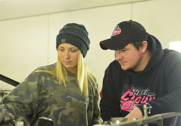 Amber Crouch (left) and crew chief/brother Timmy Crouch go over her sportsman car in preparation for the 2019 season.