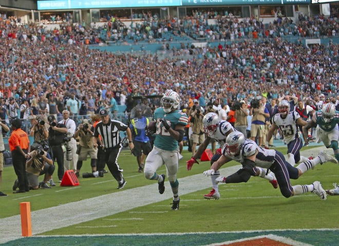 Dolphins running back Kenyan Drake (32) caps the game-winning touchdown against the Patriots by out-racing several Patriots, including tight end Rob Gronkowski, to the end zone last Sunday at Hard Rock Stadium. [DAVID SANTIAGO/Miami Herald]