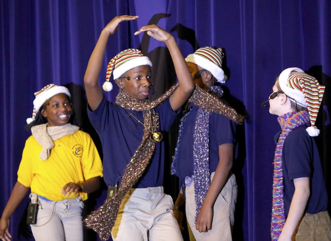 Javeyon Wilcox, 11, a fifth-grader at Rawlings Elementary, spins around on stage as he performs with fellow students (left to right) Emonshay Hampton, 10, Wade Williams, 11, and Chris Travella, 11, during the Winter Showcase at Rawlings Elementary in Gainesville Dec. 13, 2018. [Brad McClenny/The Gainesville Sun]