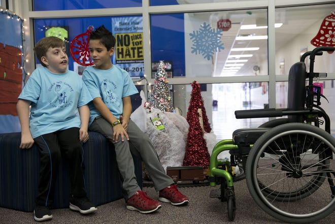 Gunnar Franchione, 9, listens to his best friend Owen Sirmons, 9, tell him a story at Blanco Vista Elementary in San Marcos on Dec. 13. The two are featured in a national commercial for Microsoft. Owen has Escobar Syndrome, a rare genetic disorder that limits his physical movement. [LYNDA M. GONZALEZ/AMERICAN-STATESMAN]