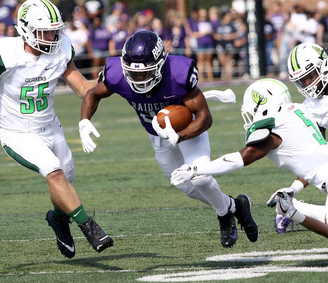 Mount Union's Jared Ruth runs between Wilmington defenders during the first half of the Raiders' Oct. 6 game at Mount Union Stadium.
