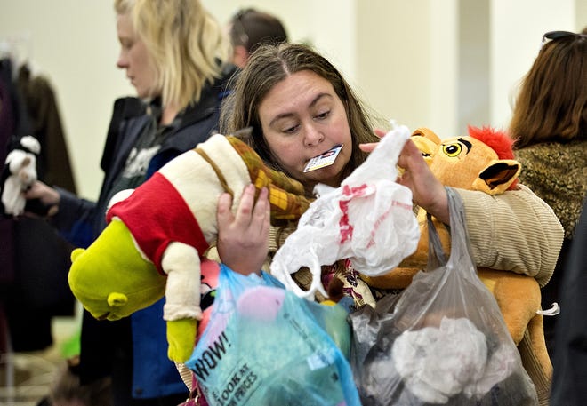 Leslie Harris has her arms full as she shops at Just BeClaus. The free gift shop that is stocked through community donations and organized by local resident Danielle Metzler is open for families in need through Saturday. [KIM WEIMER / STAFF PHOTOJOURNALIST]