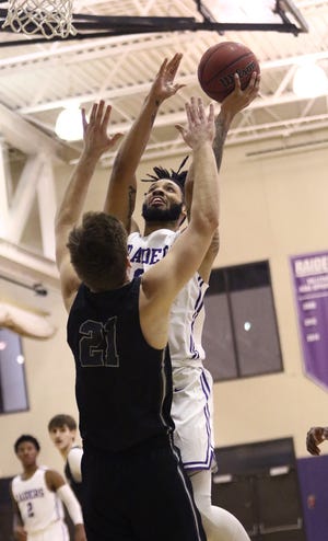Mount Union's Diallo Niamke puts up a shot defended by Heidelberg's Logan West-Holmes during league action at Mount Union Saturday afternoon.