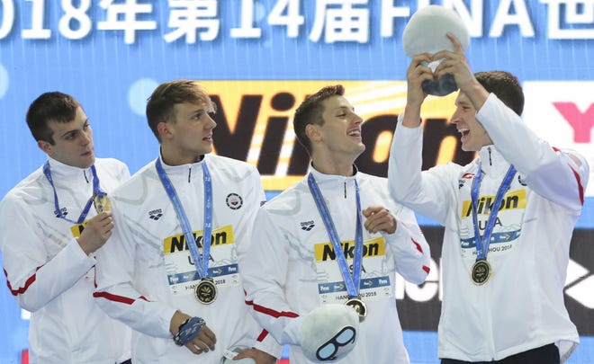 From left, American gold medalists Ryan Held, Caeleb Dressel, Andrew Wilson and Ryan Murphy celebrate during ceremonies for the men's 4x100m medley relay at Sunday's FINA World Swimming Championships 25m in China. [AP Photo/Ng Han Guan]
