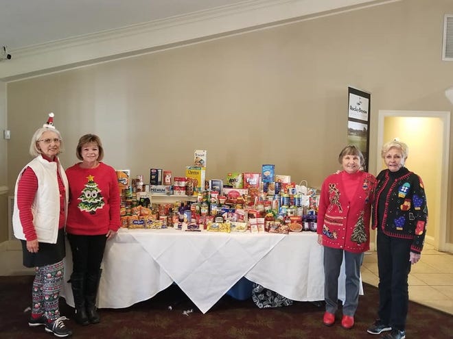 Vicki Wilson, Sharon Highsmith, Lilli Keller and Joan Hegarty, board members of the Rocky Bayou Country Club Ladies Golf Association stand by their table of donations at a recent club meeting. The club raised $910 for the Empty Stocking Fund and $190 and 242 pounds of groceries for Sharing & Caring in Niceville. [CONTRIBUTED PHOTO]