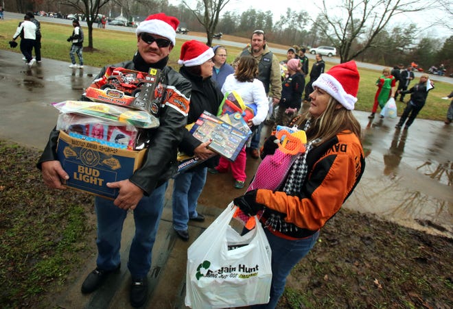 Bikers line up with toys in hand outside Aaron’s House for the 30th annual Windjammers Toy Run on Saturday. [Brittany Randolph/The Star]