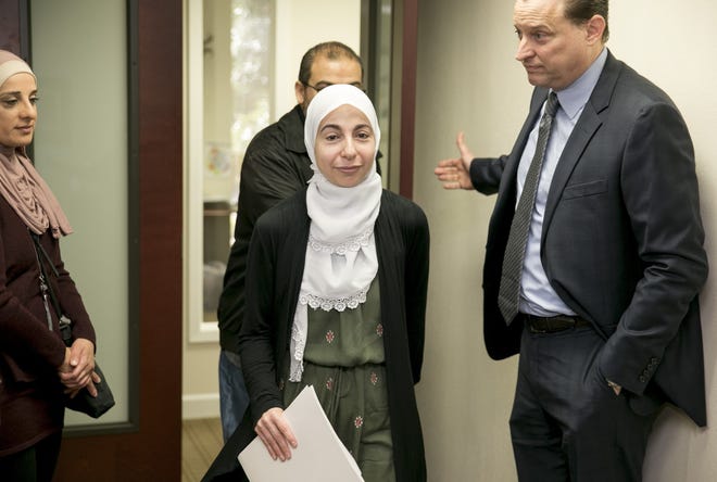 Bahia Amawi, middle, an elementary school speech pathologist from Round Rock, and her attorney John Floyd, right, arrive for a news conference at the Austin office of the Council on American-Islamic Relations on Monday. [JAY JANNER/AMERICAN-STATESMAN]