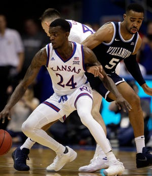 Kansas guard Lagerald Vick (24) locks arms with Villanova guard Phil Booth (5) during the second half of an NCAA college basketball game in Lawrence, Kan., Saturday, Dec. 15, 2018. Kansas defeated Villanova 74-71. (AP Photo/Orlin Wagner)