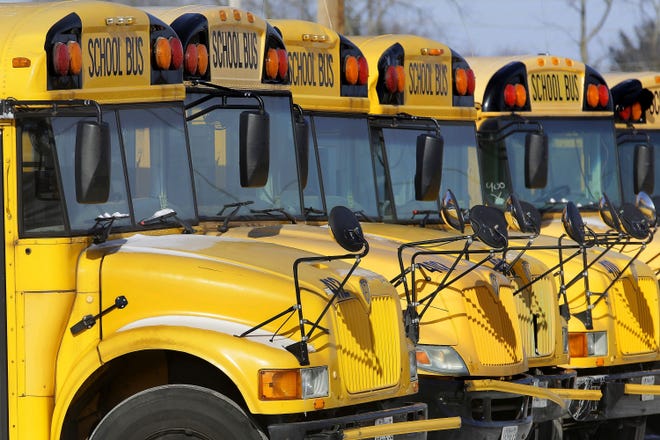 FILE - This Jan. 7, 2015 file photo shows public school buses parked in Springfield, Ill. Child abuse increases the day after school report cards are released _ but only when kids get their grades on a Friday, a Florida study released on Monday, Dec. 17, 2018 suggests. (AP Photo/Seth Perlman, File)
