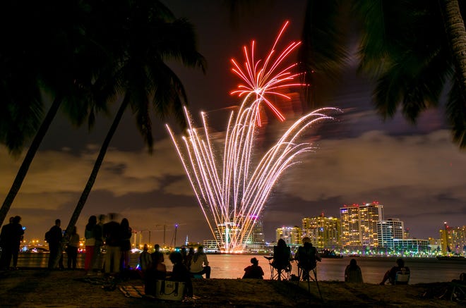 People watch the fireworks from the Lake Trail next to the Flagler Museum with the West Palm Beach skyline in the background, December of 2016 in Palm Beach. Industrialist and part-time Palm Beacher David Koch contracted the display for the Coconuts' New Year's Eve Celebration at The Flagler Museum. [RICHARD GRAULICH/palmbeachpost.com]