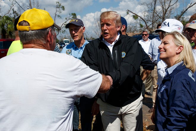 Flanked by Homeland Security Secretary Kirstjen Nielsen, right, President Donald Trump greets a Lynn Haven resident during a tour of a neighborhood affected by Hurricane Michael in this Oct. 15, 2018, file photo. The Department of Homeland Security, which has 2,313 employees in Florida, is one of the federal agencies that would be impacted by a government shutdown if Trump and Congress do not reach a funding agreement by Friday. [AP Photo / Evan Vucci]