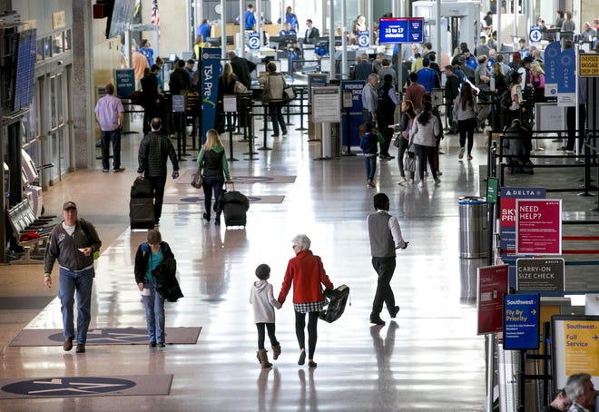 Holiday travelers walk through the concourse on a busy day at Austin-Bergstrom International Airport on Thursday December 22, 2016. JAY JANNER / AMERICAN-STATESMAN